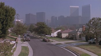 Movie still from “The Big Picture” (1989), directed by Christopher Guest – Cars driving down a street in front of a city skyline; Extreme Wide shot, High angle