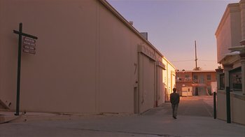 Movie still from “The Big Picture” (1989), directed by Christopher Guest – A person walking down a street near a building; Extreme Wide shot, Low angle