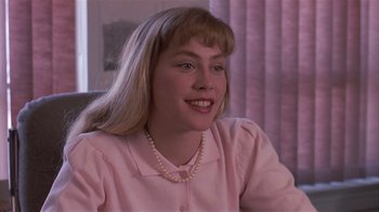 Movie still from “The Big Picture” (1989), directed by Christopher Guest – A woman in a pink shirt is sitting down; Close Up shot, Over the shoulder angle