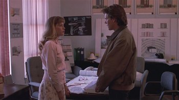 Movie still from “The Big Picture” (1989), directed by Christopher Guest – A man and a woman standing next to each other in a room; Medium shot, Over the shoulder angle