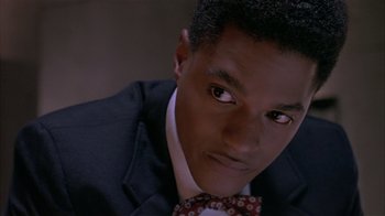Movie still from “The Big Picture” (1989), directed by Christopher Guest – A man in a suit and a bow tie looking at the camera; Close Up shot, High angle