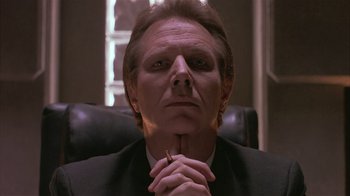 Movie still from “The Big Picture” (1989), directed by Christopher Guest – A man sitting in a chair with his hands clasped together; Close Up shot, Low angle