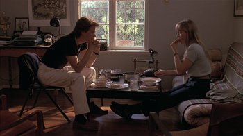 Movie still from “The Big Picture” (1989), directed by Christopher Guest – Two people are sitting in front of a coffee table drinking coffee; Wide shot, High angle
