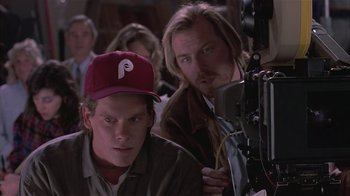 Movie still from “The Big Picture” (1989), directed by Christopher Guest – Two men are sitting in front of a camera; Close Up shot, Low angle