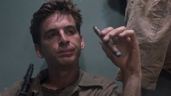 Movie still from “The Big Red One” (1980), directed by Samuel Fuller – A man looking at a cell phone while sitting down; Close Up shot, Low angle