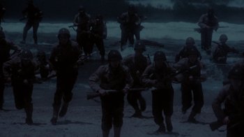 Movie still from “The Big Red One” (1980), directed by Samuel Fuller – A group of men are standing on the beach; Wide shot, High angle