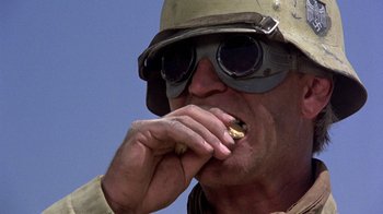 Movie still from “The Big Red One” (1980), directed by Samuel Fuller – A man in a helmet and goggles eats a piece of food; Extreme Close Up shot, Low angle