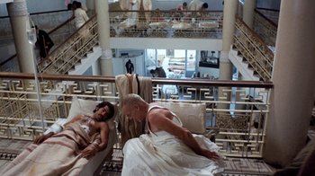 Movie still from “The Big Red One” (1980), directed by Samuel Fuller – A man and a woman laying on a bed in front of each other; Wide shot, Overhead angle