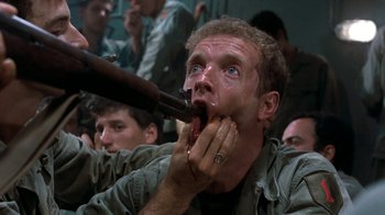 Movie still from “The Big Red One” (1980), directed by Samuel Fuller – A man with his mouth wide open while holding a rifle; Close Up shot, High angle