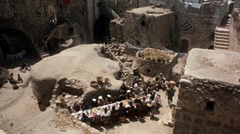 Movie still from “The Big Red One” (1980), directed by Samuel Fuller – A group of people sitting at a table in an abandoned building; Extreme Wide shot, High angle
