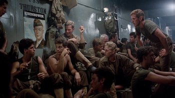Movie still from “The Big Red One” (1980), directed by Samuel Fuller – A group of men sitting next to each other in a room; Medium shot, High angle