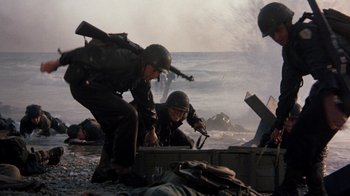 Movie still from “The Big Red One” (1980), directed by Samuel Fuller – A group of men standing next to each other on a beach; Wide shot, Low angle