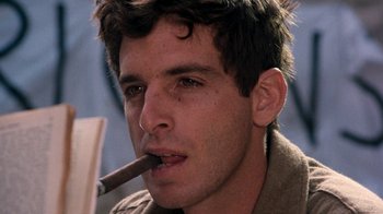 Movie still from “The Big Red One” (1980), directed by Samuel Fuller – A young man smoking a cigar while wearing a brown shirt; Close Up shot, Low angle
