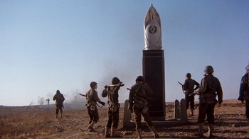 Movie still from “The Big Red One” (1980), directed by Samuel Fuller – A group of soldiers standing next to a monument; Wide shot, Low angle
