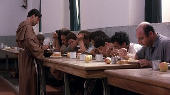 Movie still from “The Big Red One” (1980), directed by Samuel Fuller – A group of people sitting at a long wooden table; Wide shot, Over the shoulder angle