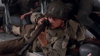 Movie still from “The Big Red One” (1980), directed by Samuel Fuller – A man with a helmet on and a rifle in his hand; Close Up shot, High angle
