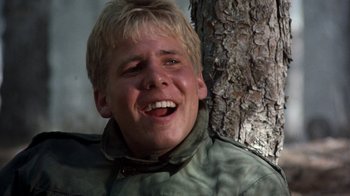 Movie still from “The Big Red One” (1980), directed by Samuel Fuller – A young man smiling while leaning against a tree; Close Up shot, Low angle