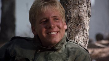 Movie still from “The Big Red One” (1980), directed by Samuel Fuller – A young man smiling for the camera next to a tree; Close Up shot, Low angle