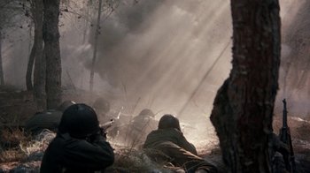 Movie still from “The Big Red One” (1980), directed by Samuel Fuller – A group of soldiers in a field with smoke billowing from the ground; Wide shot, High angle