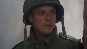 Movie still from “The Big Red One” (1980), directed by Samuel Fuller – A man wearing a military uniform and a helmet; Close Up shot, High angle