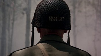 Movie still from “The Big Red One” (1980), directed by Samuel Fuller – A man wearing a military helmet in front of a waterfall; Close Up shot, Over the shoulder angle
