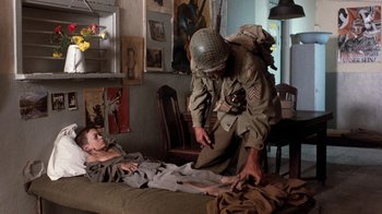 Movie still from “The Big Red One” (1980), directed by Samuel Fuller – An old man in a military uniform helping a young boy; Wide shot, High angle