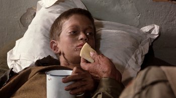 Movie still from “The Big Red One” (1980), directed by Samuel Fuller – A person is eating a piece of food while laying in bed; Close Up shot, Over the shoulder angle