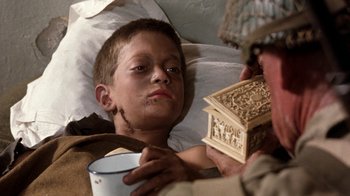 Movie still from “The Big Red One” (1980), directed by Samuel Fuller – A young boy in a hospital bed holding a wooden box; Close Up shot, Over the shoulder angle