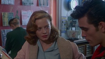 Movie still from “The Big Town” (1987), directed by Harold Becker – A woman in a pink jacket sitting in front of a mirror; Close Up shot, Over the shoulder angle