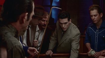 Movie still from “The Big Town” (1987), directed by Harold Becker – A group of men in suits and ties sitting around a table; Medium shot, High angle