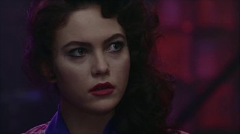 Movie still from “The Big Town” (1987), directed by Harold Becker – A person with long black hair; Close Up shot, Over the shoulder angle