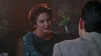 Movie still from “The Big Town” (1987), directed by Harold Becker – A woman sitting in front of a table; Close Up shot, Over the shoulder angle