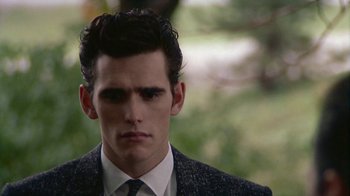 Movie still from “The Big Town” (1987), directed by Harold Becker – A man in a suit and tie looking at the camera; Close Up shot, Low angle