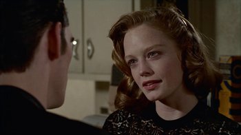 Movie still from “The Big Town” (1987), directed by Harold Becker – A young woman is looking at a man in a room; Close Up shot, Over the shoulder angle