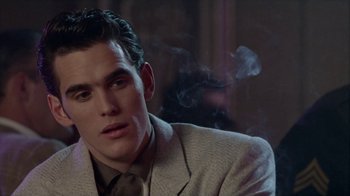 Movie still from “The Big Town” (1987), directed by Harold Becker – A man in a suit smoking a cigarette in front of a mirror; Close Up shot, Over the shoulder angle