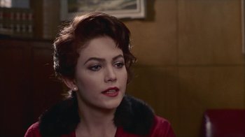 Movie still from “The Big Town” (1987), directed by Harold Becker – A woman in a red dress is looking at the camera; Close Up shot, Over the shoulder angle