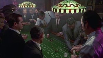 Movie still from “The Big Town” (1987), directed by Harold Becker – A group of men playing a game of craps; Wide shot, High angle