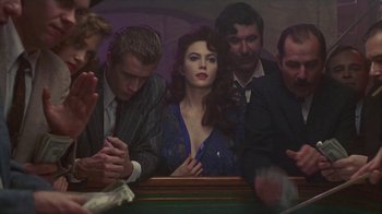 Movie still from “The Big Town” (1987), directed by Harold Becker – A group of people sitting around a table; Medium shot, Over the shoulder angle