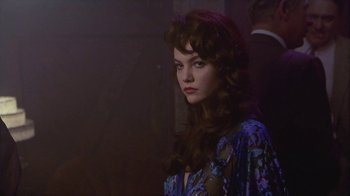 Movie still from “The Big Town” (1987), directed by Harold Becker – A beautiful young woman with long brown hair; Medium shot, Over the shoulder angle