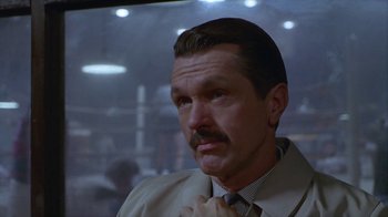 Movie still from “The Big Town” (1987), directed by Harold Becker – A person wearing a suit and tie; Close Up shot, Low angle