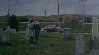 Movie still from “The Big Town” (1987), directed by Harold Becker – Two people hug in front of an old red car; Extreme Wide shot, High angle