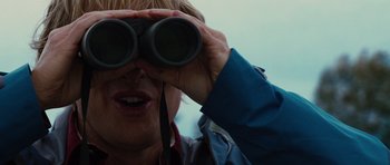 Movie still from “The Big Year” (2011), directed by David Frankel – A woman looking through a pair of binoculars; Close Up shot, Low angle
