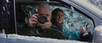 Movie still from “The Big Year” (2011), directed by David Frankel – A man taking a picture of a woman in the back of a car; Medium shot, Over the shoulder angle