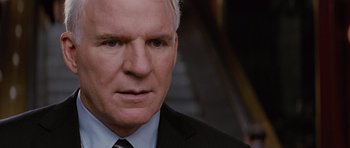Movie still from “The Big Year” (2011), directed by David Frankel – A man in a suit and tie looking at the camera; Close Up shot, Over the shoulder angle