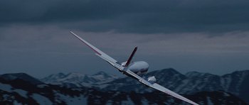 Movie still from “The Big Year” (2011), directed by David Frankel – An airplane is flying through the air over the mountains; Extreme Wide shot, Low angle