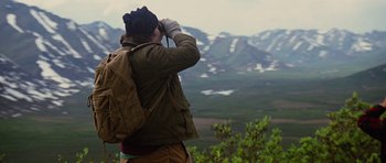 Movie still from “The Big Year” (2011), directed by David Frankel – A woman looking out over a valley while using binoculars; Medium shot, Over the shoulder angle