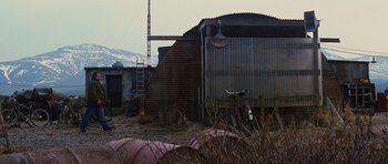 Movie still from “The Big Year” (2011), directed by David Frankel – An old building with a cow standing in front of it; Extreme Wide shot, Low angle
