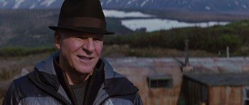 Movie still from “The Big Year” (2011), directed by David Frankel – A person wearing a hat near a mountain; Close Up shot, Over the shoulder angle