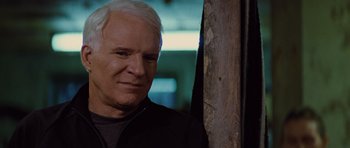 Movie still from “The Big Year” (2011), directed by David Frankel – An older man standing next to a wooden post; Close Up shot, Over the shoulder angle