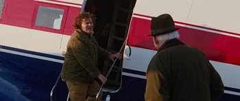 Movie still from “The Big Year” (2011), directed by David Frankel – A man is getting out of an airplane; Medium shot, Over the shoulder angle
